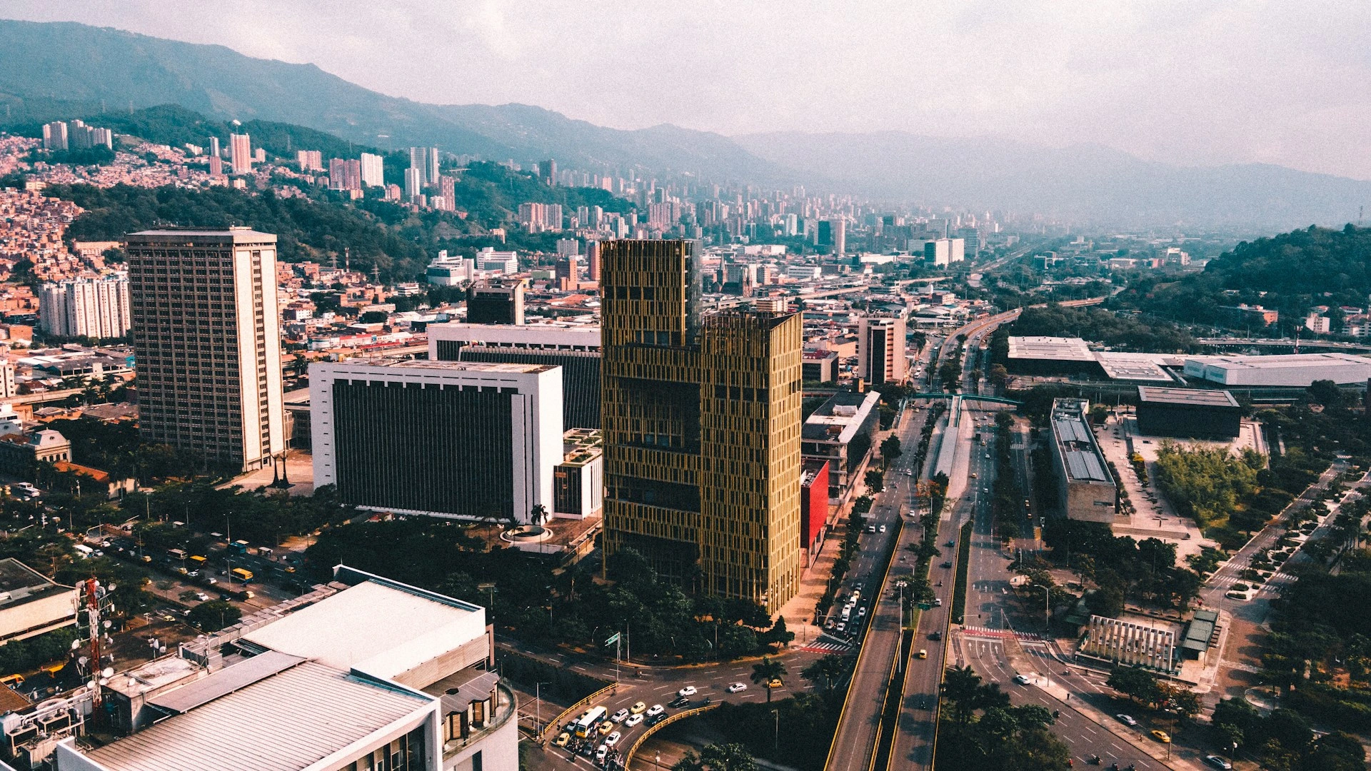 Vista aérea de la avenida principal de Medellín con montañas de fondo