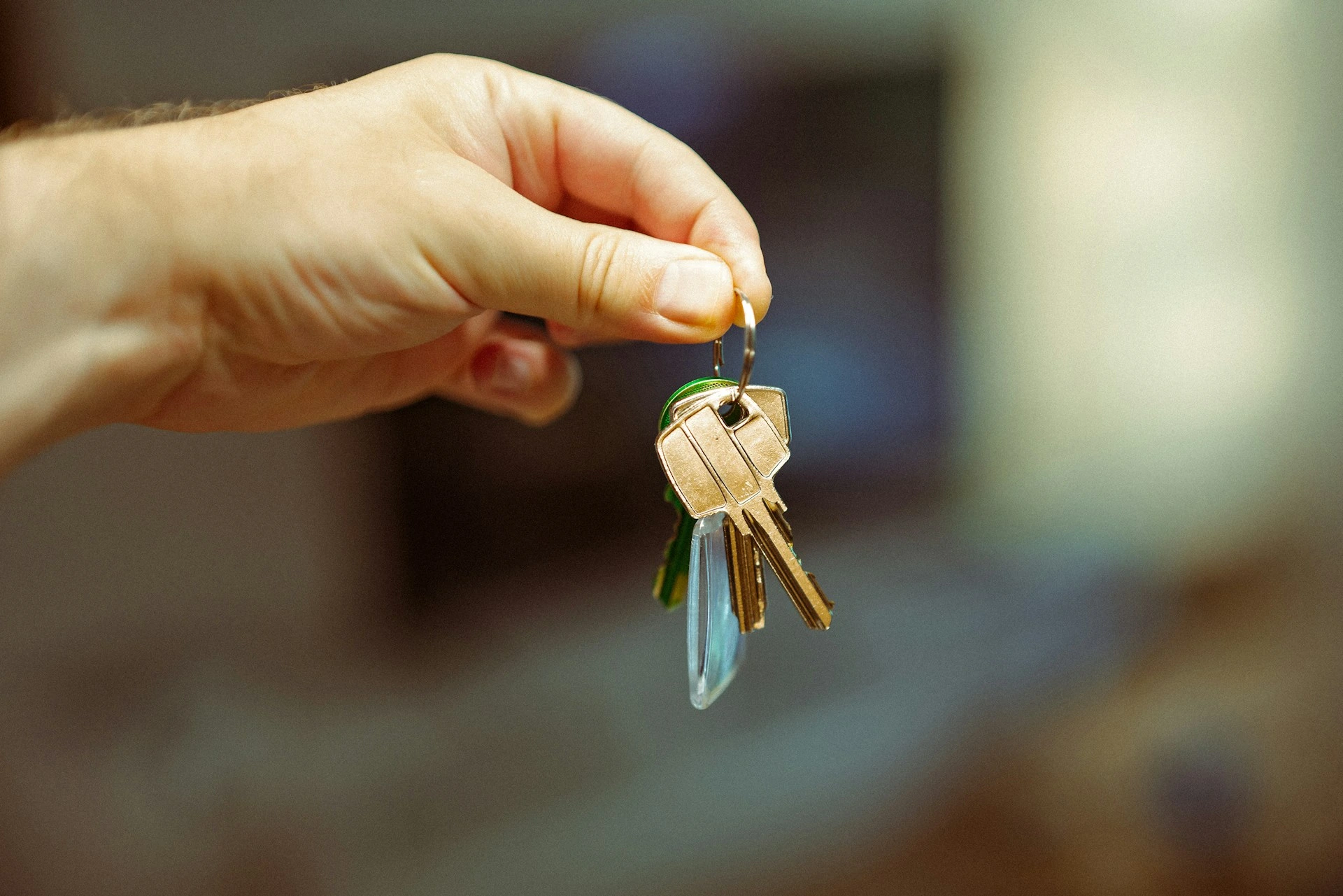 Mano sosteniendo llaves de un apartamento nuevo