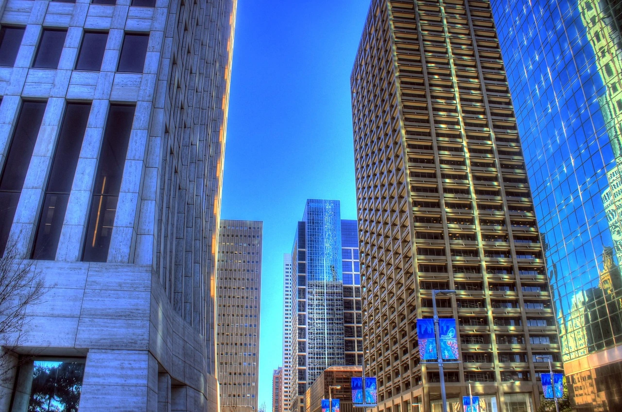 A modern cityscape at dusk with a busy highway in the foreground